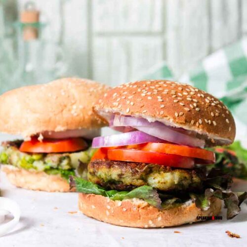 Veg Burger with sliced onion, tomato and lettuce greens between sesame buns