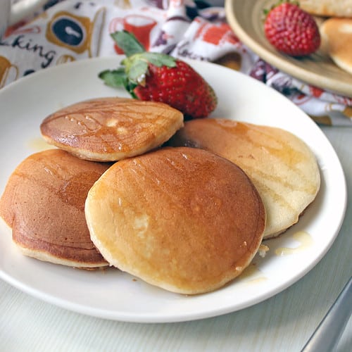 Homemade fluffy pancakes served with fresh strawberries